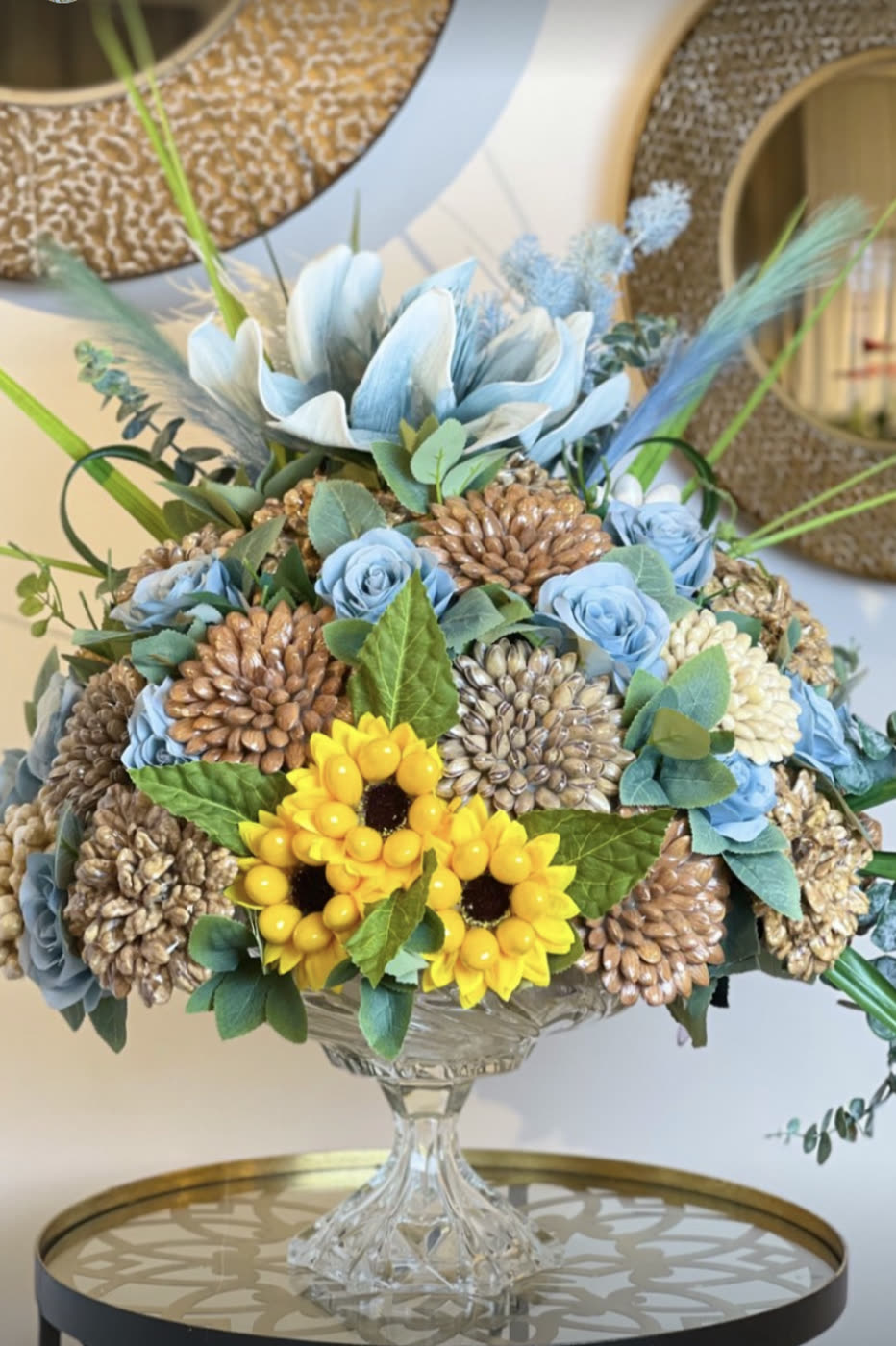 Crystal vase with blue dried flowers and sunflowers
