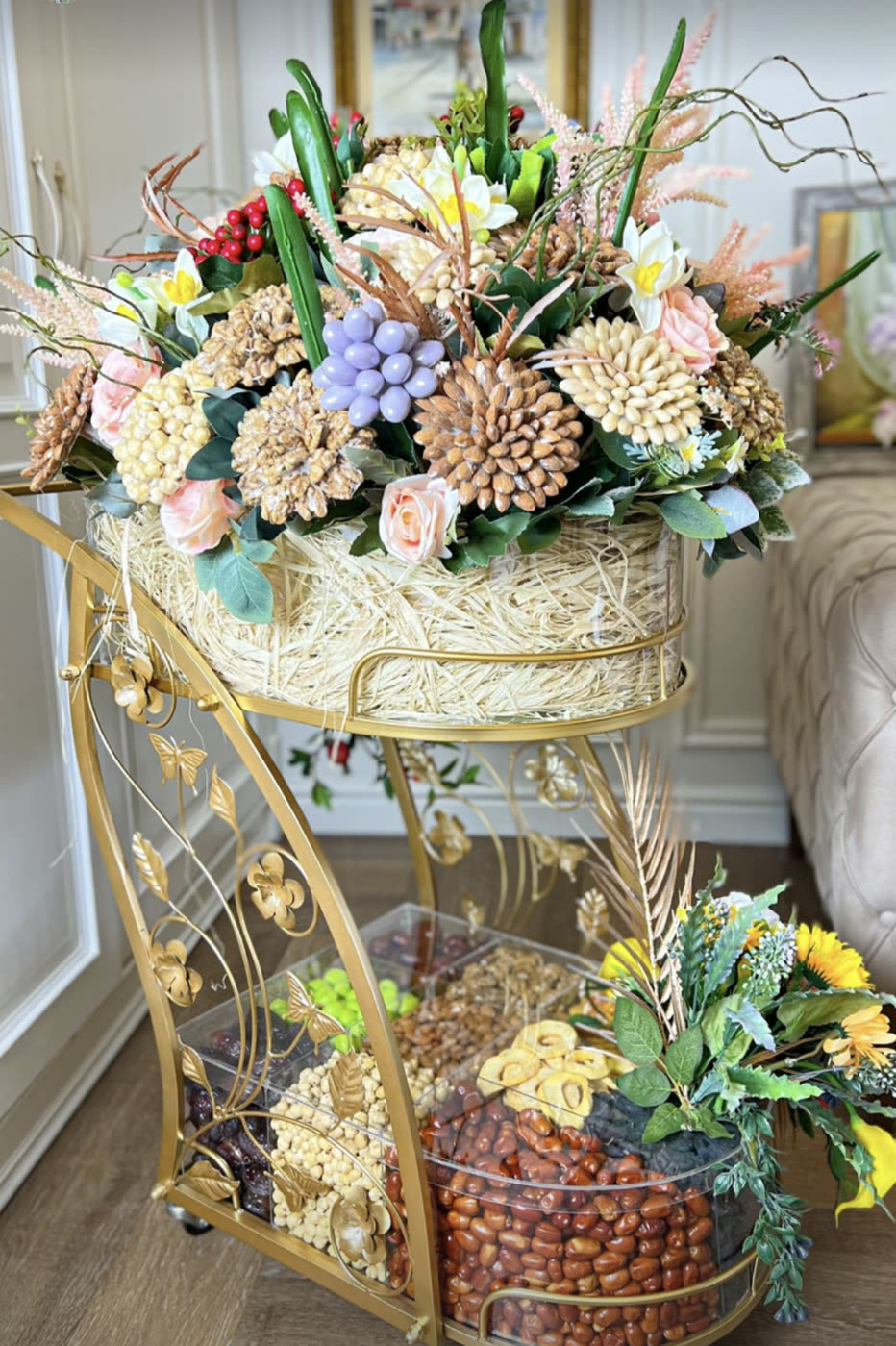 Gold two‑tier cart with flowers and a tray of nuts
