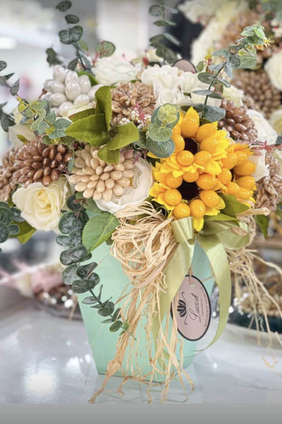 Mint vase of sunflowers, roses and eucalyptus with raffia