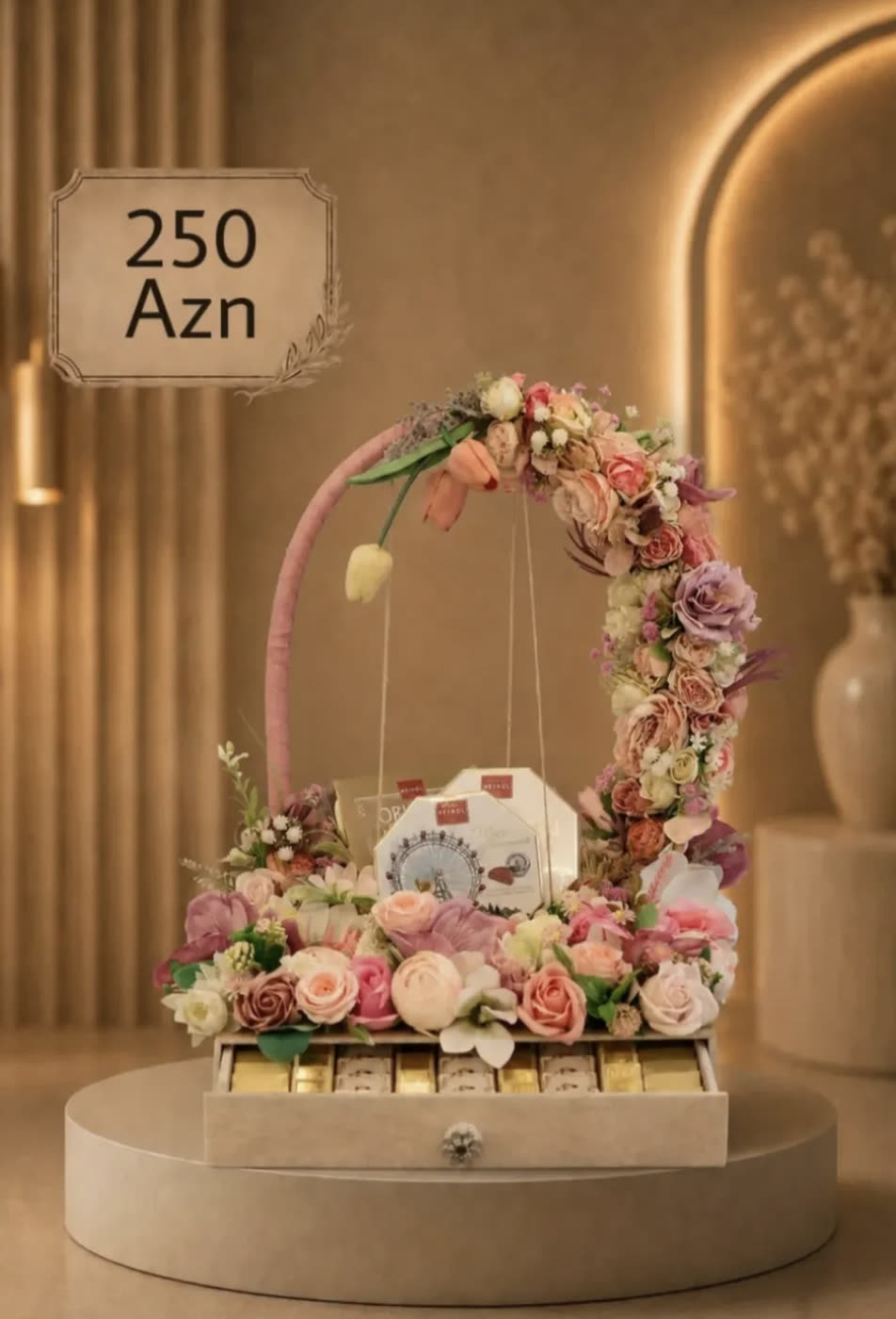 Box of chocolates under an arch of pink dried flowers
