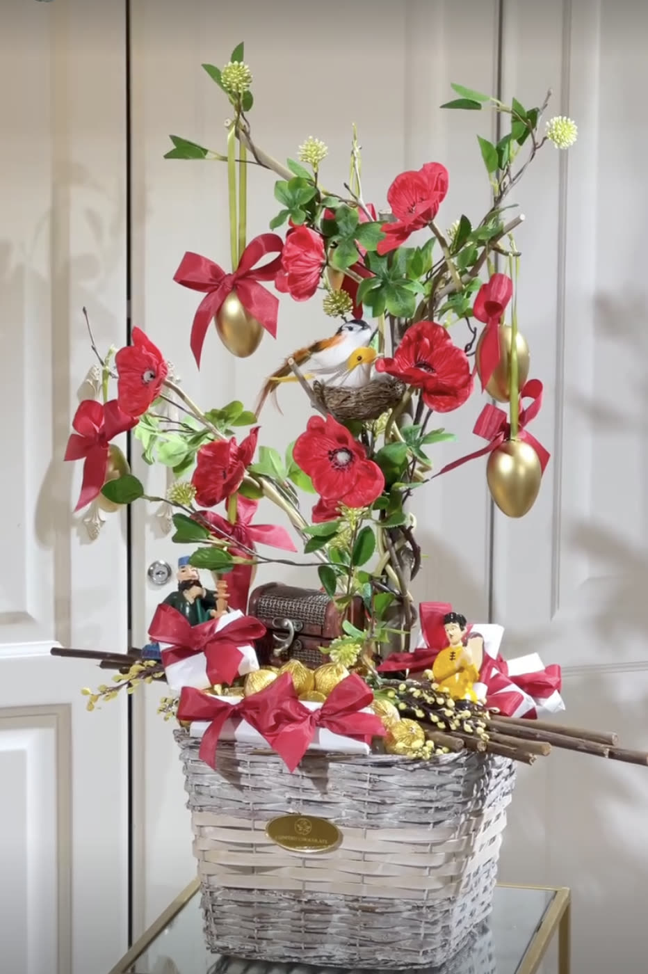 Wicker basket arrangement with red anthuriums and gold eggs
